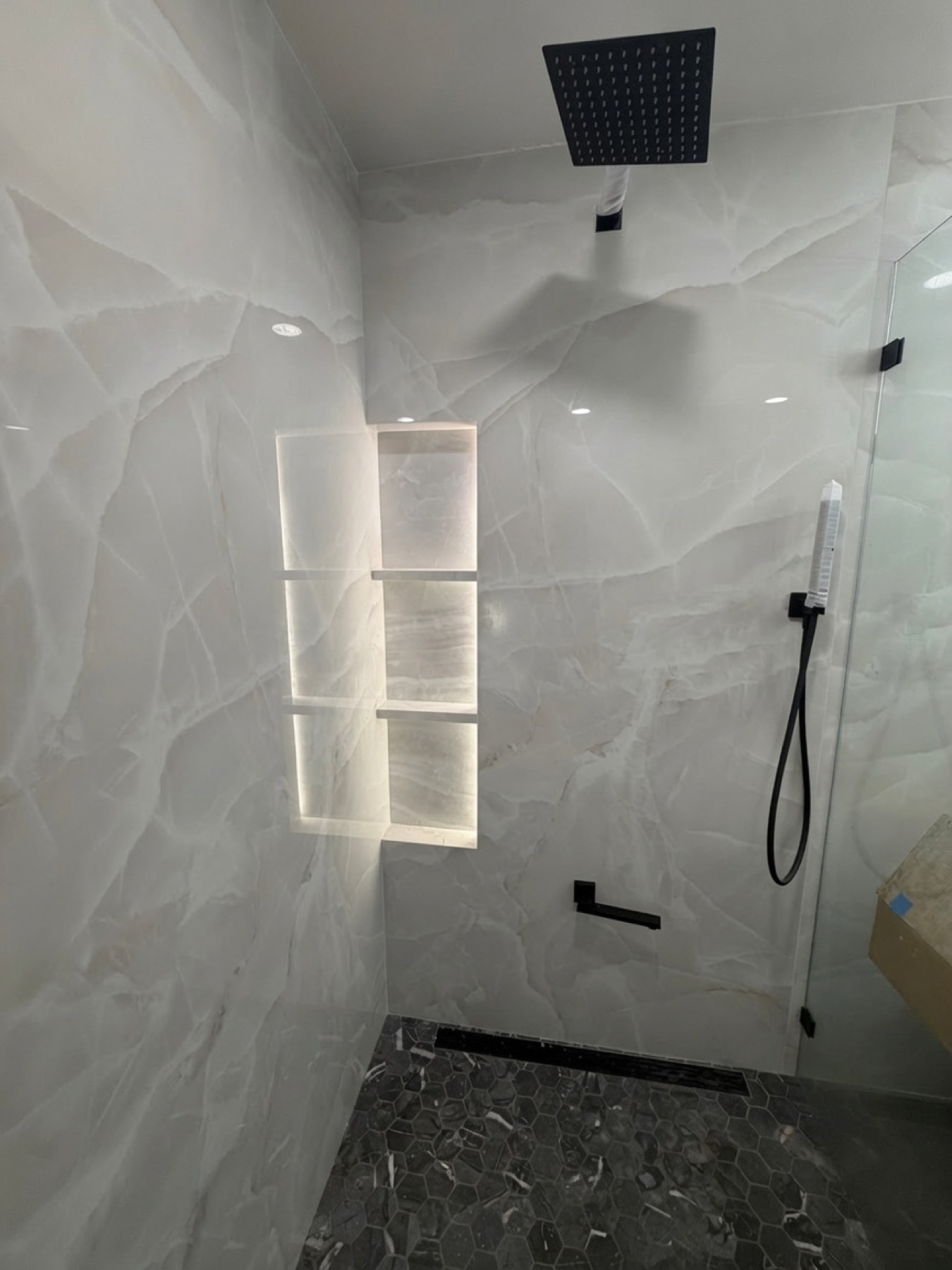 Marble shower with softly illuminated recessed niche shelves