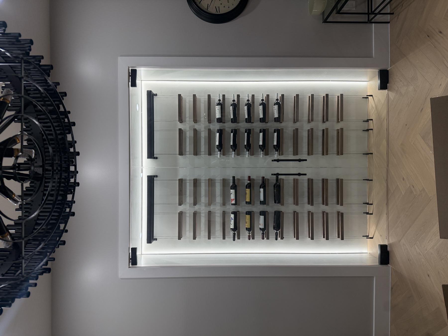 Glass-front wine wall with LED perimeter halo and floating cable racks